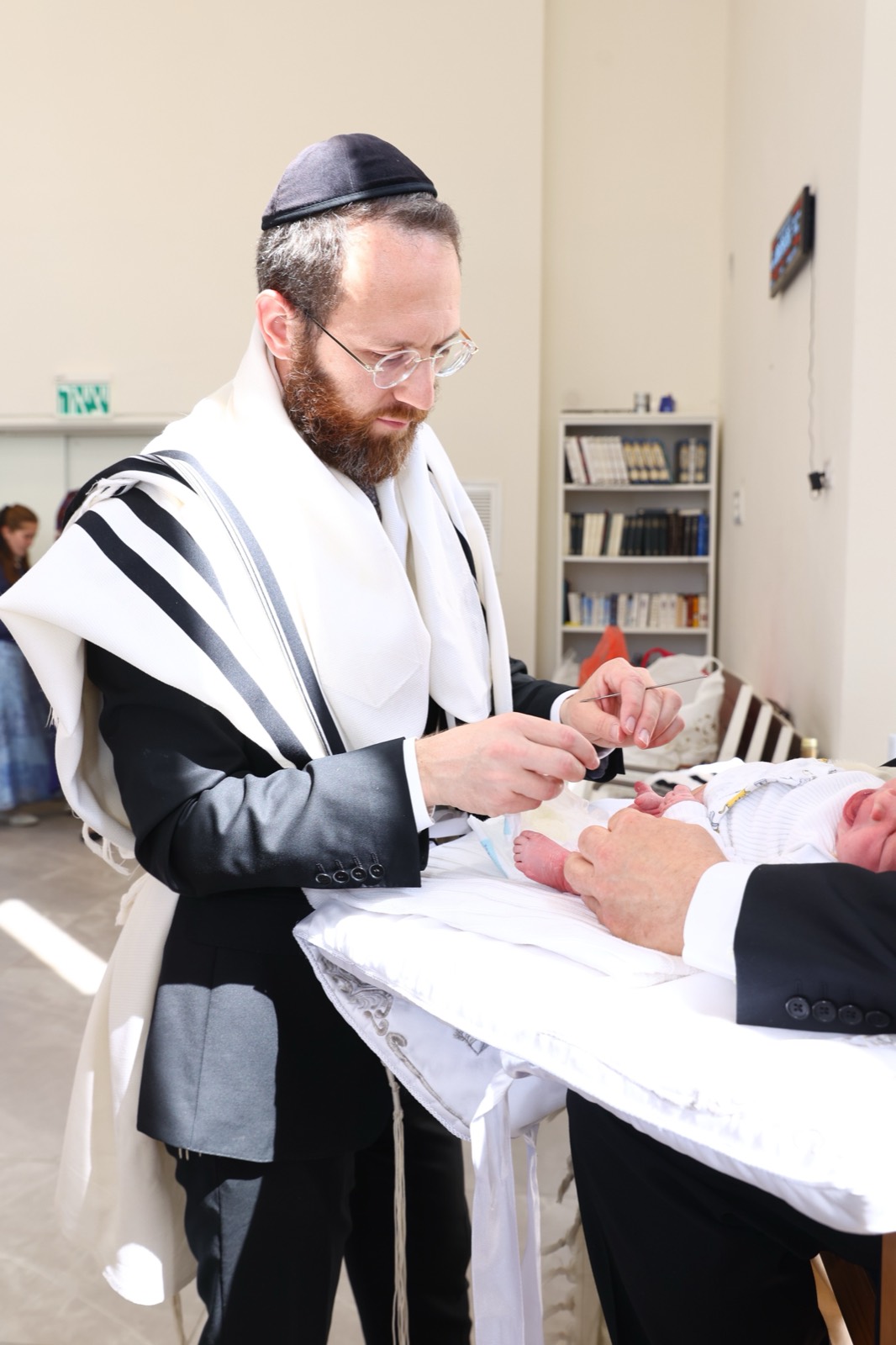 Rabbi Grossman performing the bris with focused care